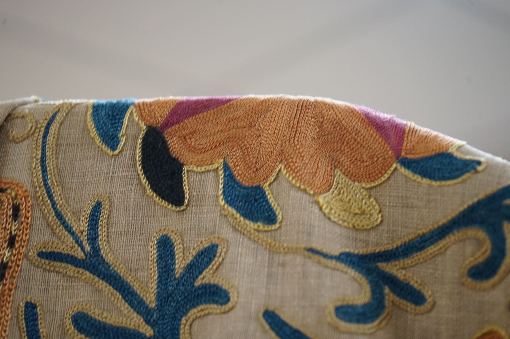 A 19th century, circa 1850-1880 hand embroidered Suzani wall hanging, probably from Uzbekistan. Worked on had woven linen, predominantly embroidered in orange, ochre, maroon and green silks in fine chain stitch with an o